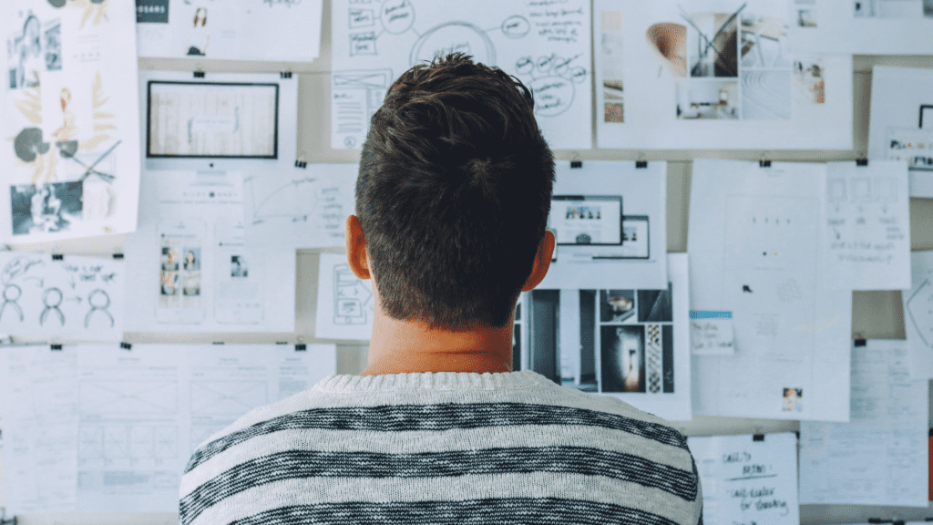 Man pondering a wall with lots of ideas