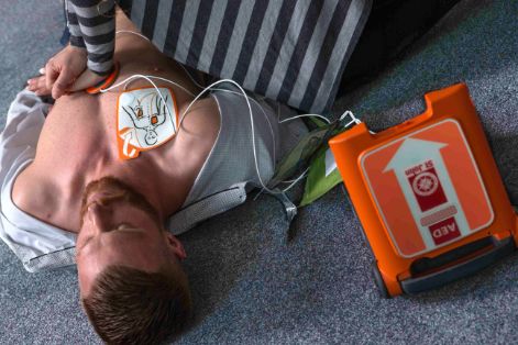 man getting first aid with the help of a defibrillator that hopefully have no tech debt.