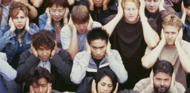 group of people covering their ears